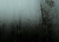 Atmospheric close-up of raindrops on a window, capturing a serene and moody scene.
