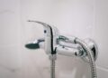 A detailed view of a sleek chrome shower faucet in a clean bathroom setting.