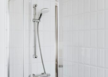 Stylish shower setup with chrome fixtures and clean white tiles.