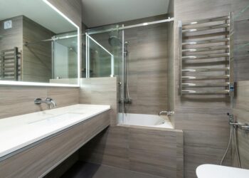 Elegant modern bathroom featuring a bathtub, shower, and sleek stainless steel fixtures.