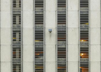 Detailed view of a multi-storey building facade featuring grid windows and modern architectural design.