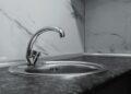 A clean and modern kitchen sink with a chrome faucet, highlighting minimalist design and water conservation.