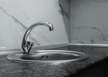 A clean and modern kitchen sink with a chrome faucet, highlighting minimalist design and water conservation.