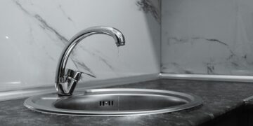 A clean and modern kitchen sink with a chrome faucet, highlighting minimalist design and water conservation.