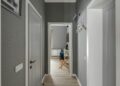 Spacious hallway with grey walls, wooden doors and white hangers, leading into a modern room.