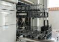 Open and empty dishwasher in a sunlit modern kitchen ready for use.