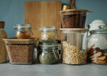 Stylish pantry setup with a variety of foods in glass storage jars, showcasing dry goods and cookies.