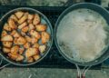 Delicious roasted potatoes and soup simmering outdoors, offering a rustic culinary experience.