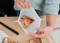 Person storing bread in a reusable silicone bag, promoting zero waste lifestyle.
