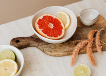 Bright citrus slices displayed in bowls on a wooden board, offering a fresh, minimalist aesthetic.