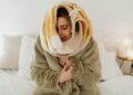 Woman wrapped in a fluffy blanket enjoying a cozy moment at home.