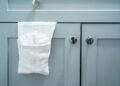 Close-up of a white towel on a modern gray bathroom cabinet door.