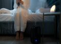A serene bedroom scene with humidifier mist illuminating soft lighting, creating a calm atmosphere.