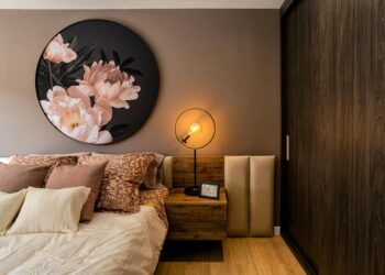 Elegant bedroom interior featuring floral artwork and warm lighting creating a cozy atmosphere.