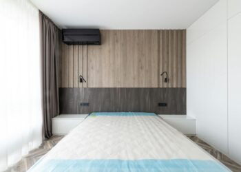 Sleek and modern bedroom featuring a minimalist design with wooden paneling and neutral tones.