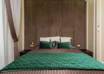 Cozy modern bedroom with green bedding and soft lighting. Ideal for contemporary design inspiration.