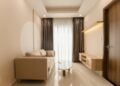 A minimalist living room with a beige sofa, modern table, and soft lighting.