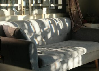 Modern gray sofa in a sunlit living room showcasing elegant interior design.