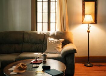 A warm, inviting living room interior featuring a sofa, coffee table, and floor lamp.