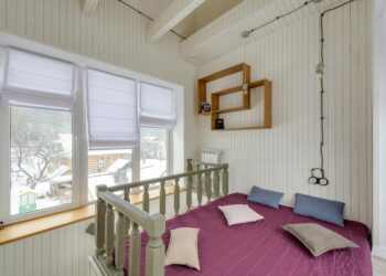 Bright chalet interior with white walls and snowy outdoor view through windows.