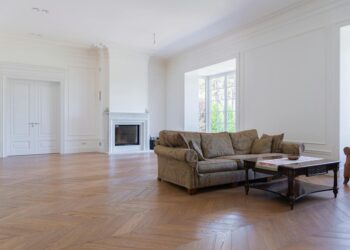 Beautiful spacious living room featuring elegant modern furniture and hardwood floors.