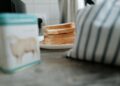 Close-up of sliced bread on a ceramic plate beside a striped cloth. Perfect for cozy kitchen or breakfast themes.