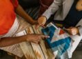 Two professionals assessing colorful fabric swatches for interior design project.