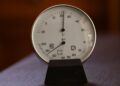 Close-up of an analog hygrometer and thermometer displaying temperature and humidity indoors.