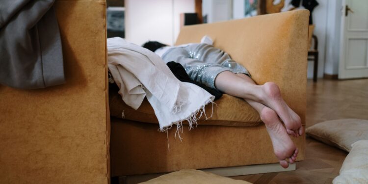 A person relaxing barefoot on a cozy sofa indoors, enjoying a peaceful moment.