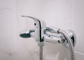 A detailed view of a sleek chrome shower faucet in a clean bathroom setting.
