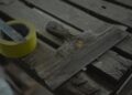 Close-up of a spatula and duct tape on an aged wooden surface. Perfect for DIY and renovation themes.