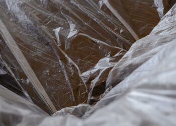Close-up of transparent plastic sheeting over a wooden surface, revealing textures.