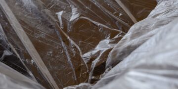 Close-up of transparent plastic sheeting over a wooden surface, revealing textures.