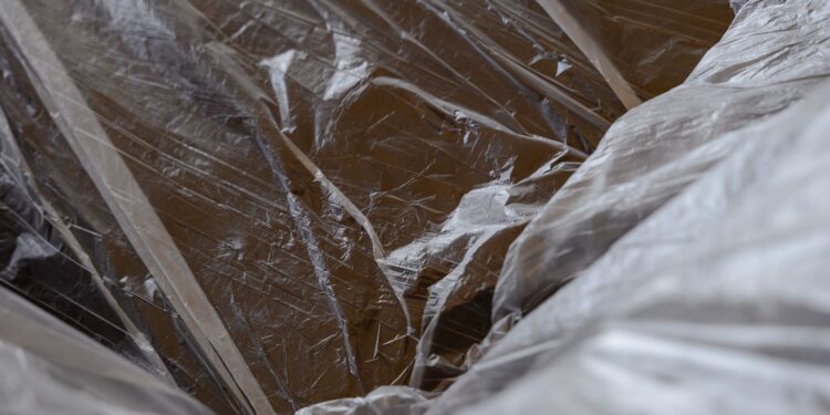 Close-up of transparent plastic sheeting over a wooden surface, revealing textures.