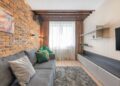 Stylish living room interior featuring a rustic brick wall, comfortable gray sofa, and elegant decor.