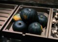 A rustic wooden box filled with fresh Kabocha squash, ideal for autumn cuisine.