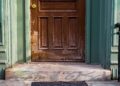 A close-up view of an old wooden door with peeling paint and vintage charm.