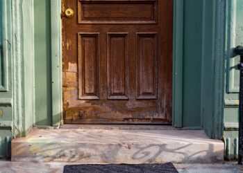 A close-up view of an old wooden door with peeling paint and vintage charm.