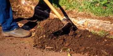 Close-up of gardener working soil using a hoe in Londrina, Brazil.