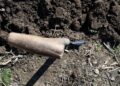 A shovel in freshly turned soil, ideal for gardening or farming themes.