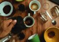 Dynamic overhead photo of coffee being poured into mugs with spills and stained cups.