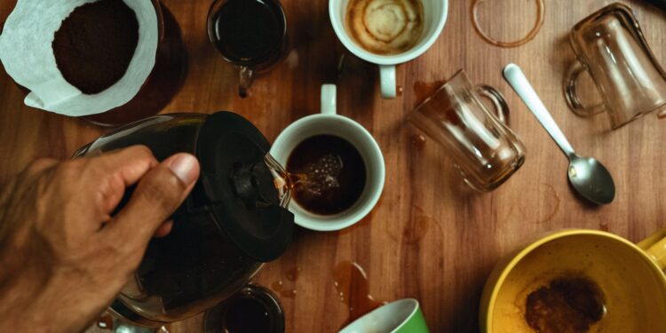 Dynamic overhead photo of coffee being poured into mugs with spills and stained cups.